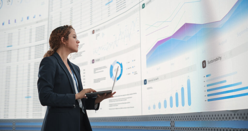 Data Aquisition; A business professional analyzing data migration processes on a large digital dashboard, evaluating trends and migration risks while using advanced data migration tools for seamless system transitions.